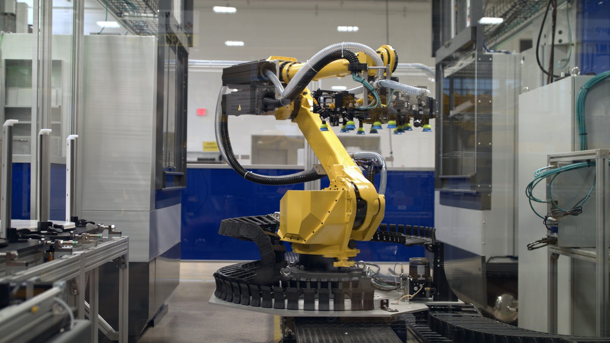 Six-axis robot with multiple degrees of freedom and EOAT moves material between process modules.