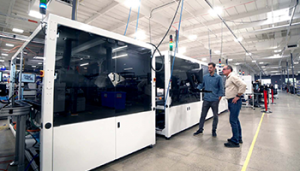 Engineers collaborating on automated battery manufacturing line.